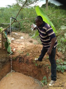 Un membre de l'Association prend sa première gorgée d'eau du nouveau puits